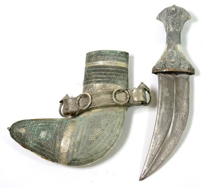 Lot 395 - An Arab Jambiya, the curved blade with raised medial ridge, white metal-mounted grip and scabbard