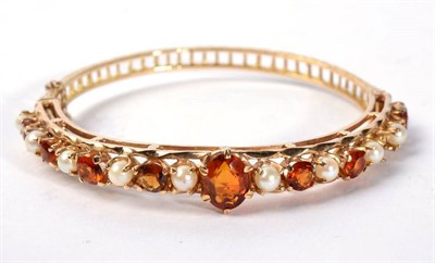 Lot 123 - A 9 carat gold citrine and seed pearl bangle, 16.1g