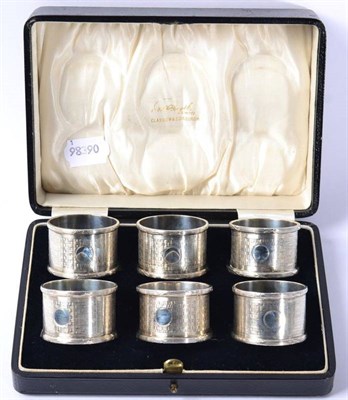 Lot 230 - A matched set of six silver napkin rings, Birmingham 1914/18, with engine turned decoration, in...