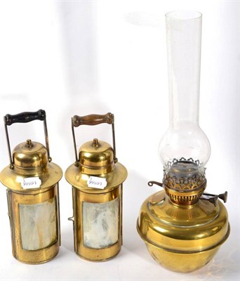 Lot 324 - A Victorian brass oil lamp and two later cylindrical form oil lamps with turned wooden handles