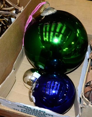 Lot 1101 - A large green witches ball, with two smaller blue and silver examples (3)
