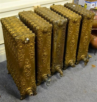 Lot 1179 - A set of five gilded cast iron Victorian radiators
