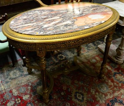 Lot 1187 - A 19th century French gilded and marble topped table of oval form (a.f)