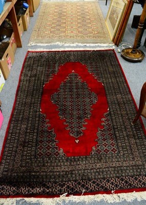 Lot 1244 - An Indo-Persian rug, the central geometric lozenge on a red ground; together with another (2)