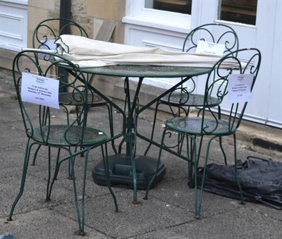 Lot 1253 - A modern painted metal circular garden table; a set of four matching chairs and a parasol