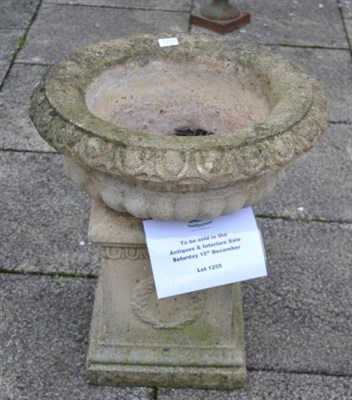 Lot 1255 - A composition bird bath with gadrooned body raised on a square sectioned plinth