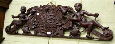 Lot 1274 - A 19th century wall carving depicting two winged cherubs flanking a coat of arms