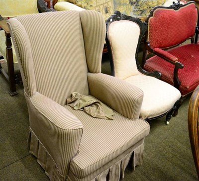 Lot 1354 - An early 20th century wingback armchair, recovered in striped fabric