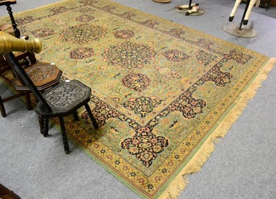 Lot 1426 - A large Persian design green ground machine made carpet