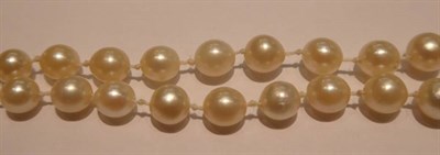 Lot 214 - An early 20th century graduated cultured pearl necklace, with a lozenge-shaped diamond set...
