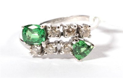 Lot 216 - A 9 carat white gold green garnet and diamond crossover ring, a cushion cut and a trilliant cut...