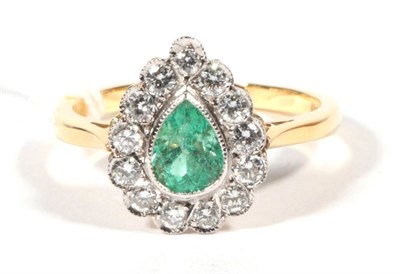 Lot 232 - An 18 carat gold emerald and diamond cluster ring, a grain set pear cut emerald within a border...