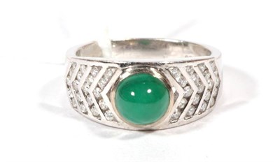 Lot 248 - An emerald and diamond ring, an oval cabochon emerald in a rubbed over setting, to tapering channel