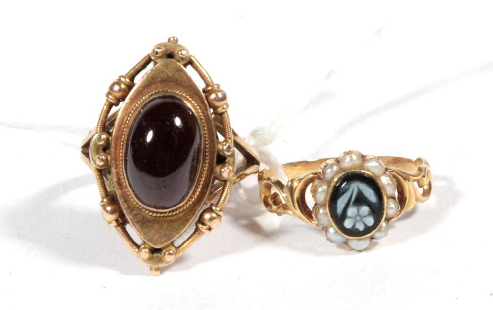 Lot 251 - A Victorian onyx and seed pearl mourning ring, carved depicting a forget-me-not within a border...