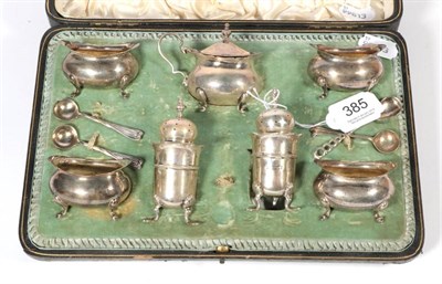 Lot 385 - A seven piece silver condiment set, London 1901, with some associated spoons, in a fitted case,...