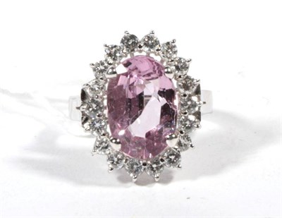 Lot 497 - A pink spinel and diamond cluster ring, an oval cut pink spinel within a border of round...