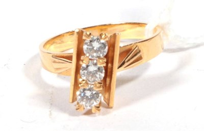 Lot 499 - A diamond three stone ring, diagonally set round brilliant cut diamonds in claw setting between two