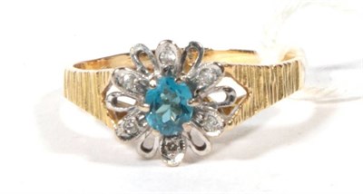 Lot 508 - An 18 carat gold, blue topaz and diamond cluster ring, with textured shoulders, finger size S, 4.2g