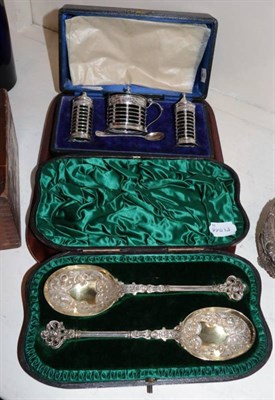 Lot 567 - A silver three piece condiment set, Birmingham 1911, with openwork sides, in a fitted case; and...