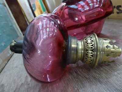Lot 1165 - A pink satin glass oil lamp and shade; together with other lamps and plates