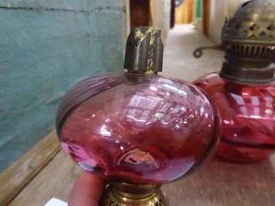 Lot 1165 - A pink satin glass oil lamp and shade; together with other lamps and plates