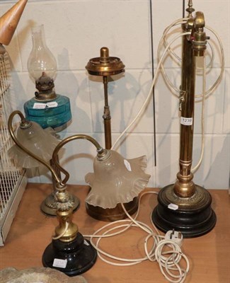 Lot 1239 - ~ Four late Victorian lamps comprising: a brass example with scrolled arm support with later...