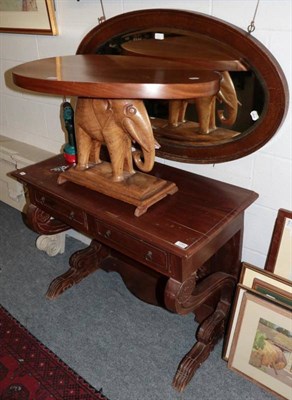 Lot 1293 - A carved hardwood oval elephant table and a 20th century two drawer writing table on carved support