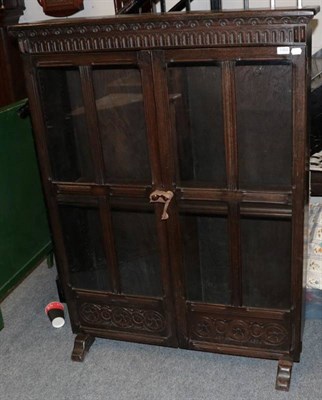 Lot 1302 - A 20th century carved oak and glazed bookcase