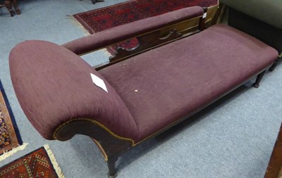 Lot 1362 - ~ A late Victorian oak framed chaise longue recovered in purple fabric, the plain seat rail...