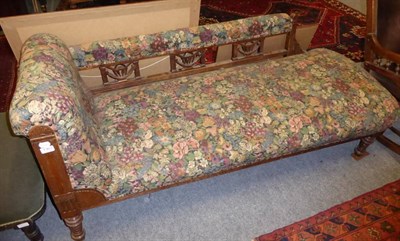 Lot 1363 - ~ A late Victorian walnut framed chaise longue, later covered in floral close nailed fabric...