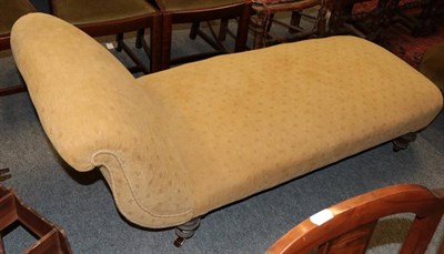 Lot 1367 - ~ A late Victorian chaise longue recovered in yellow fabric raised on turned legs with brass...