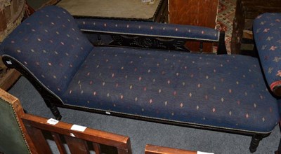 Lot 1372 - ~ A late Victorian ebonised chaise longue, re-upholstered in blue and geometric pattern fabric with