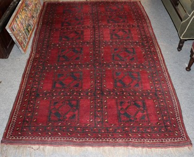 Lot 1389 - Afghan carpet, the claret field with two columns of guls enclosed by narrow borders, 220cm by 142cm