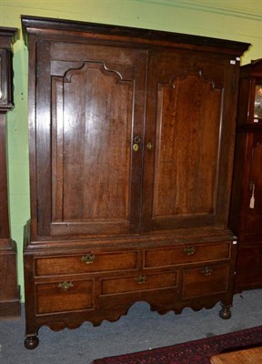 Lot 1406 - An 18th century oak press cupboard with moulded cupboard doors, the base with five drawers...