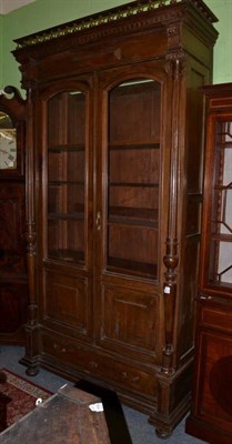 Lot 1415 - ~ A 19th century French walnut bookcase with a balustrade gallery above glazed and panelled...