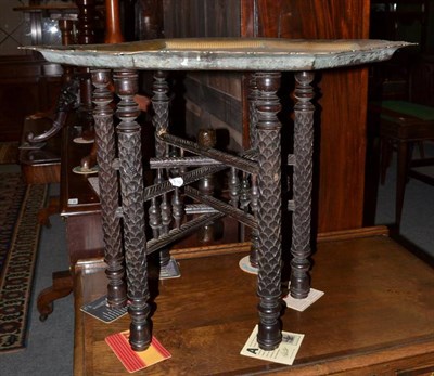 Lot 1439 - Early 20th century brass octagonal shaped tray, with carved hardwood folding stand, 61cm diameter