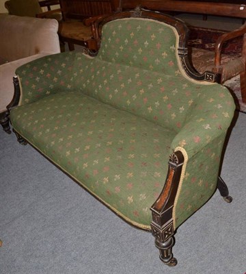 Lot 1444 - ~ A Victorian ebonised burr walnut sofa, late 19th century, upholstered in a green fleur de lis...