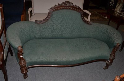 Lot 1474 - ~ A Victorian carved walnut serpentine shaped sofa, late 19th century, recovered in green...