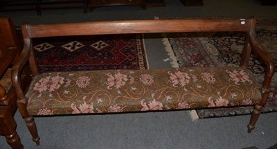 Lot 1497 - ~ A Victorian mahogany three seater bench recovered with floral fabric and over stuffed seat raised