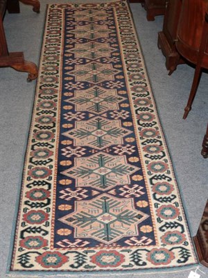 Lot 1536 - Anatolian Runner, the indigo field with a column of stellar motifs enclosed by ivory borders, 278cm