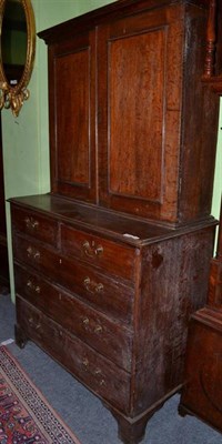 Lot 1555 - ~ A George III oak press cupboard late 18th century with a bold cornice above two cupboard...