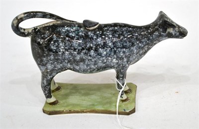 Lot 302 - A Pearlware Cow Creamer and Stopper, circa 1810, the standing beast with black sponged markings, on