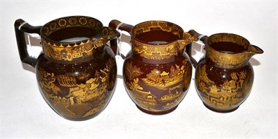 Lot 310 - A Graduated Set of Three Nelson Commemorative Brown Glazed Pottery Jugs, circa 1805, printed in...