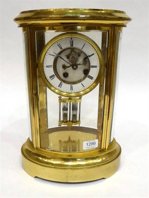 Lot 1286 - An Oval Shaped Brass Four Glass Mantel Clock, circa 1890, bevelled glass panels, 4-1/2-inch...