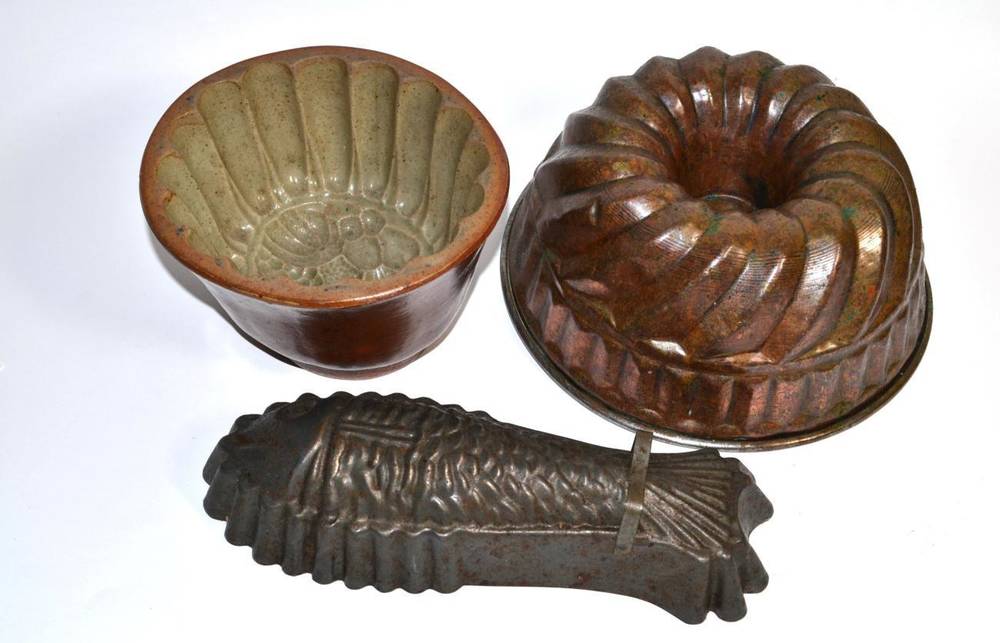 Lot 7 - A Victorian pottery jelly mould; a copper example; and a later fish form example