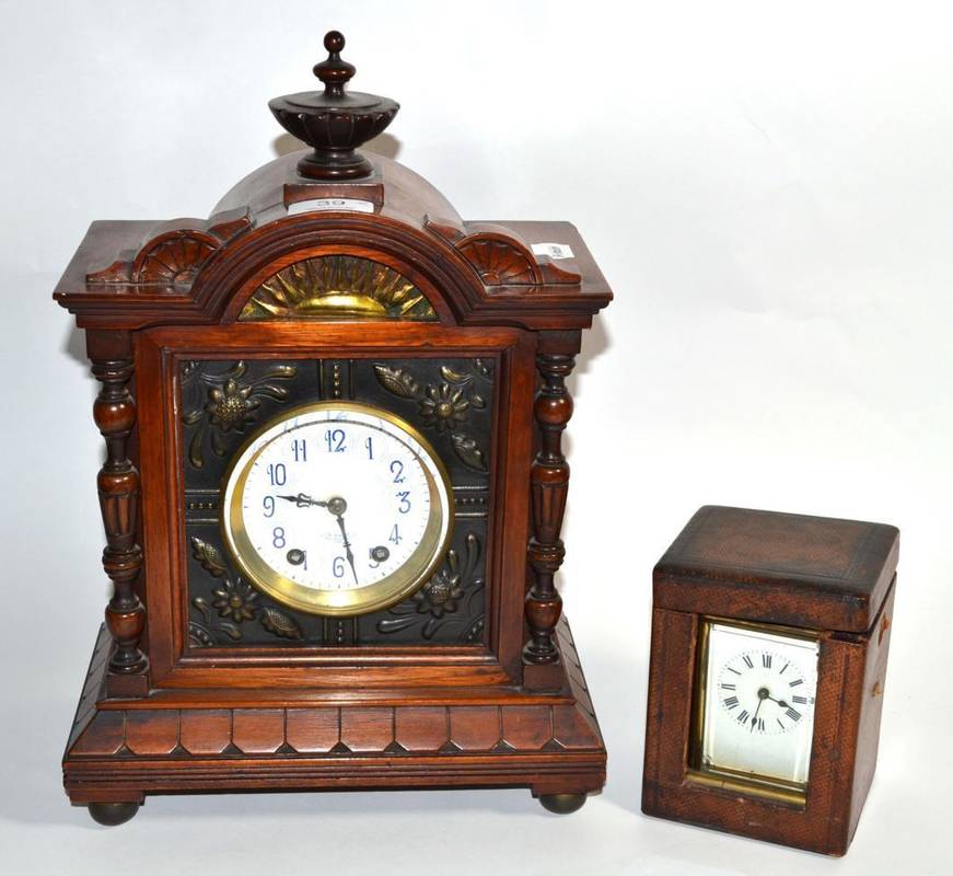 Lot 39 - A walnut cased striking mantle clock with floral embossed front and side panels retailed by...