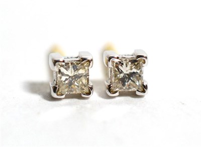 Lot 61 - A pair of 18 carat gold solitaire princess cut diamond earrings, in square claw settings, total...