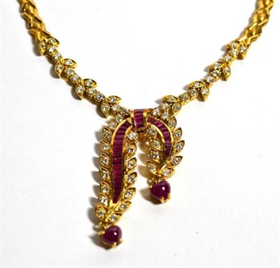 Lot 73 - A ruby and diamond necklace, a scroll front with channel set calibré cut ruby ribbons, with...