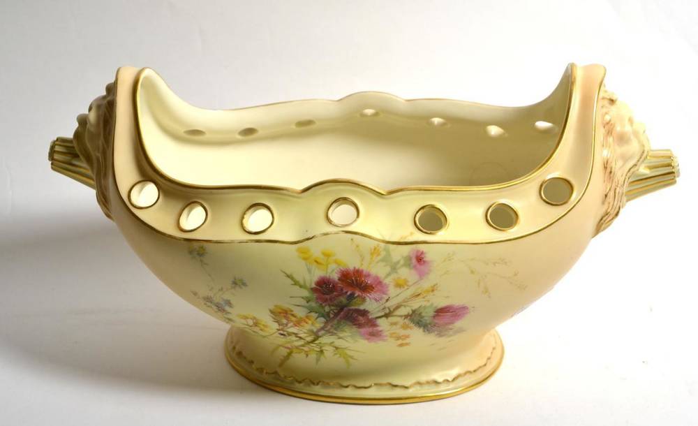 Lot 188 - A Royal Worcester blush ivory twin handled flower bowl with lion mask handles painted with...