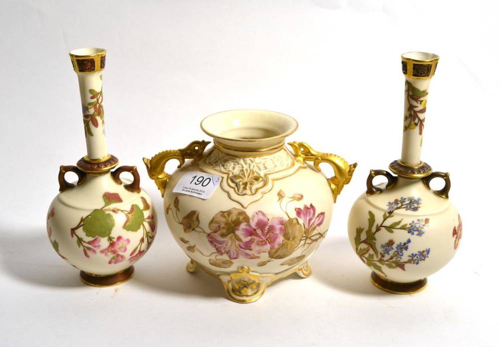 Lot 190 - A pair of Royal Worcester blush ivory twin handled bottle vases decorated with floral sprays...
